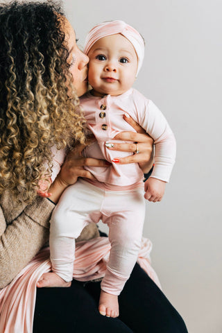Lou Lou and Company Top and Bottoms - Emily
Woman holding a baby dressed in pink against a plain background