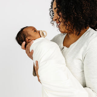 Lou Lou and Company Swaddle Blanket - Finley
Woman holding a swaddled baby against a white background