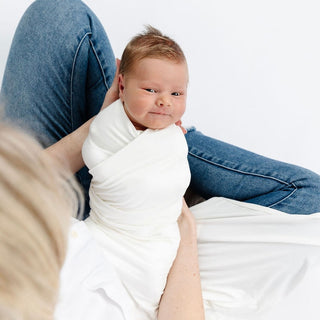 Lou Lou and Company Swaddle Blanket - Finley
Newborn baby wrapped in a white blanket being held by a person on a white background