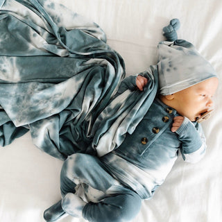 Lou Lou and Company Top and Bottoms - Mateo
Baby in blue tie-dye outfit and hat lying on a white blanket