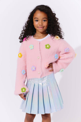 Lola and The Boys 3D Rainbow Daisy Cardigan Young girl wearing a pink cardigan with floral embellishments and a pleated skirt on a white background