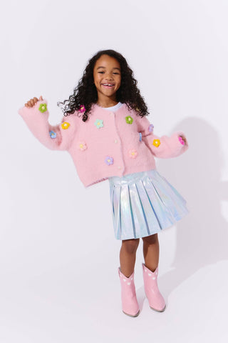 Lola and The Boys 3D Rainbow Daisy Cardigan Child wearing a pink sweater with colorful buttons, a light blue skirt, and pink boots on a white background