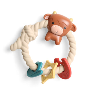 Itzy Ritzy Rattle Teether - Highland Cow Teething ring with cow design and colorful teethers on a white background