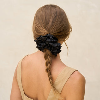 Kitsch Black Ruffle Scrunchie
Woman with braided hair wearing a black scrunchie on a beige background