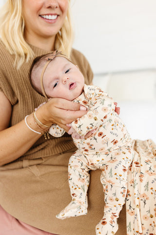 Lou Lou and Company Top and Bottoms - Rachel
Woman holding a baby wearing a floral outfit in a home setting