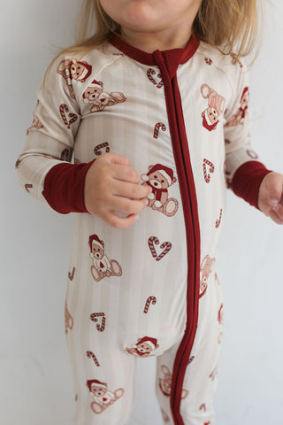 In My Jammers Bear-y Merry Zipper Romper
Child wearing a pajama with teddy bear and candy cane patterns on a plain background