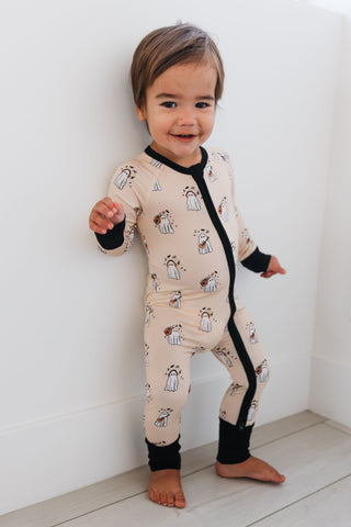 In My Jammers DJ BooMBox Zipper Romper Child wearing a patterned onesie standing against a white wall.