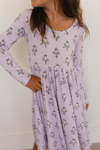 In My Jammers Ballerina Ghost Long Sleeve Twirl Dress Woman wearing a light purple dress with black patterns against a white background