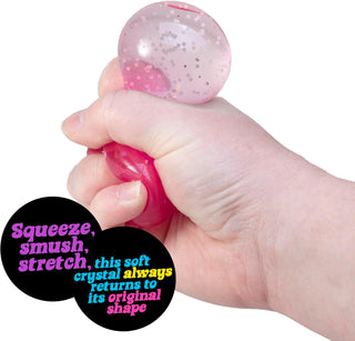 Schylling NeeDoh Groovy Jewel Hand holding a pink and clear crystal ball with text about its properties.