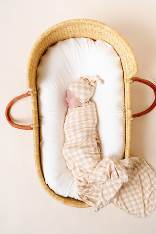 Lou Lou and Company Swaddle Blanket - Austin
Newborn baby wrapped in a swaddle blanket in a Moses basket.