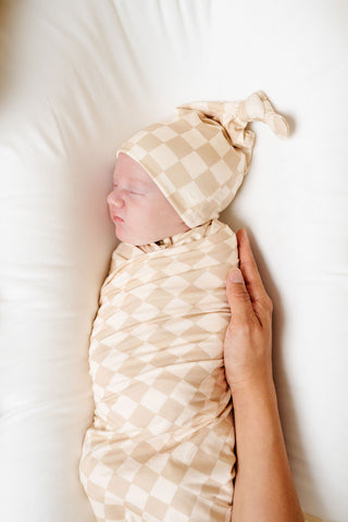 Lou Lou and Company Swaddle Blanket - Austin
Newborn baby swaddled in a checkered blanket with a matching hat, held by a hand on a white background.