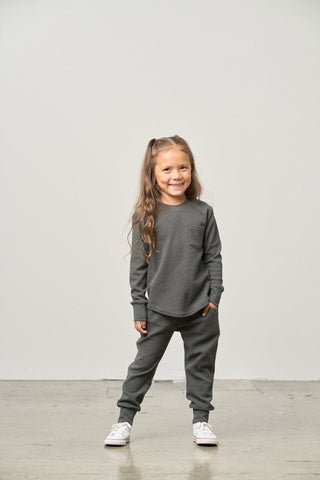 Little Bipsy Waffle Top - Shadow
Young girl wearing a gray outfit standing against a plain white background