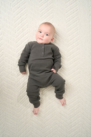 Little Bipsy Waffle Romper - Shadow
Baby wearing a dark green onesie on a textured white blanket