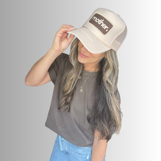 Mother Patch Trucker Hat - Sand
Person wearing a beige cap with 'mother' logo on a gray background