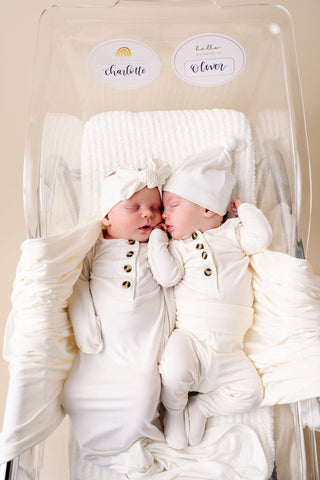 Lou Lou and Company Top and Bottoms - Finley
Two babies in matching white outfits with bows, sitting in a high chair.