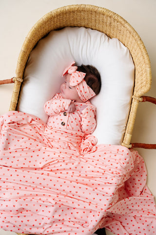 Lou Lou and Company Swaddle Blanket - Miley
Baby in a crib wearing a pink outfit with red polka dots and matching headband.