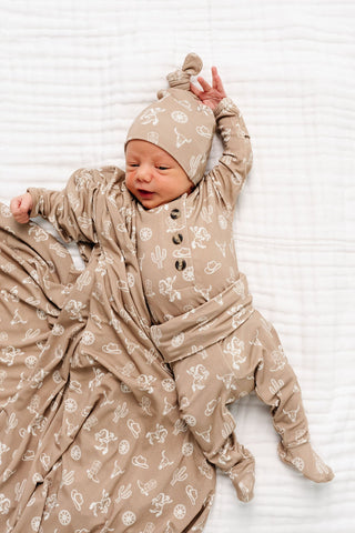 Lou Lou and Company Top and Bottoms - Wyatt
Newborn baby in a beige outfit with patterns on a white background