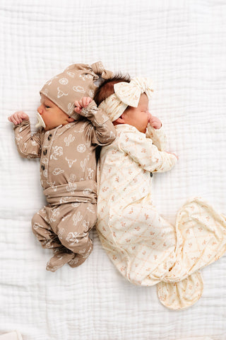 Lou Lou and Company Knotted Gown - Annie
Two babies in matching outfits lying on a white textured surface.