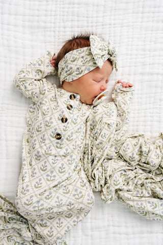 Lou Lou and Company Headband - Etta
Newborn baby in floral outfit and headband on a white textured blanket