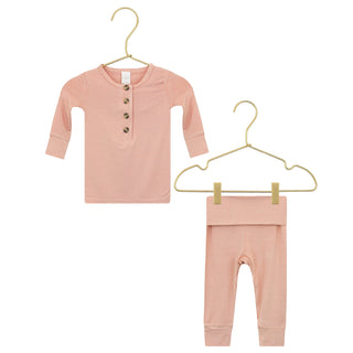 Lou Lou and Company Top and Bottoms - Abby
Pink baby outfit with shirt and pants on hangers against a white background