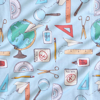 Posh Peanut Steve Ruffled Twirl Dress Educational items including globes, rulers, scissors, and glue on a light blue background