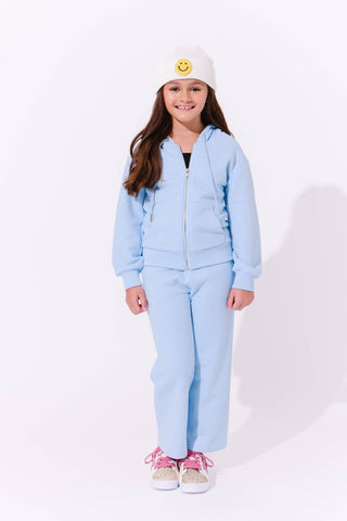 Lola and The Boys Blue Taylor Crystal Set
Child wearing a light blue outfit with a white beanie on a white background