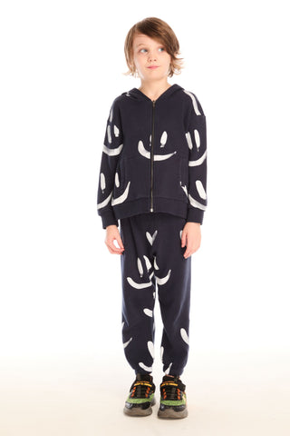 Chaser Allover Smileys Pants
Person wearing a navy blue hoodie and pants with white patterns on a white background
