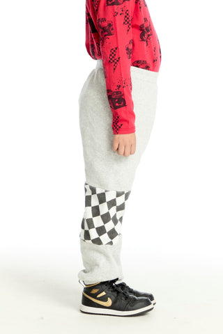 Chaser Checker Colorblock Pants
Person wearing a red hoodie, gray pants with a checkered pattern, and black sneakers on a white background
