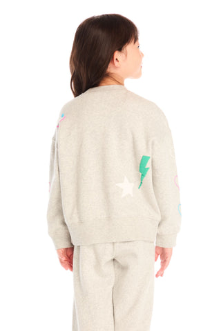 Chaser Winter Love Stitches Long Sleeve
Person wearing a light-colored outfit with graphic designs on a white background
