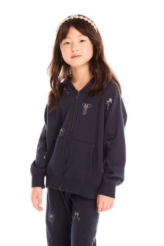 Chaser Tossed Glitter Bows Zip Up Hoodie
Young girl wearing a navy blue outfit with embroidered designs on a white background