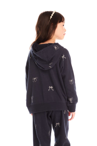Chaser Tossed Glitter Bows Zip Up Hoodie
Person wearing a navy blue hoodie with white patterns on a white background