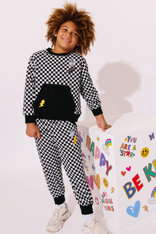 Lola and The Boys Checker Astro Patch Set
Child wearing a black and white checkered outfit with a colorful background