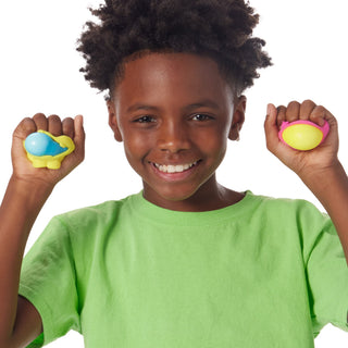 Schylling NeeDoh Dohjees 3-Pack Set Child holding two colorful stress balls against a white background