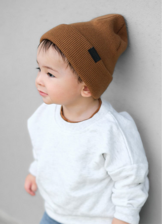 Little Bipsy Chunky Knit Beanie - Chestnut
Child wearing a brown beanie and white sweater against a gray background