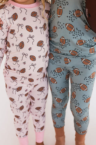 In My Jammers Blush Football Two Piece Set
Two pairs of pajama pants with football and bow pattern on a white background