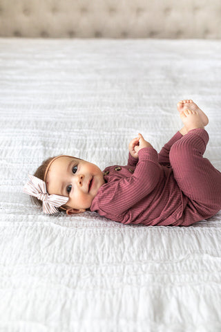 Lou Lou and Company Top and Bottoms - Marjorie
Baby in a pink outfit lying on a white bed