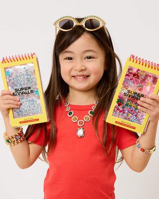 Super Smalls Make It Sweet Gemify™ Sticker Booklet Child holding two 'Super Smalls' craft books with a white background