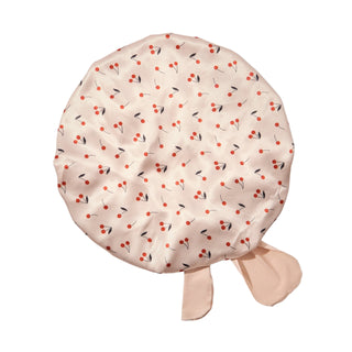 Kitsch Adjustable Oversized Satin Bonnet - Cherry Print 
Round cushion with cherry pattern on a light gray background