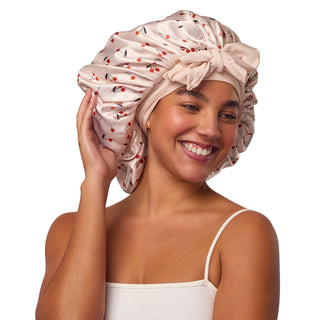 Kitsch Adjustable Oversized Satin Bonnet - Cherry Print
Woman wearing a patterned satin hair bonnet on a plain background