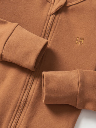 Little Bipsy 2-Way Zip Romper - Chestnut
Brown jacket with rolled-up sleeves and a visible brand logo on a neutral background