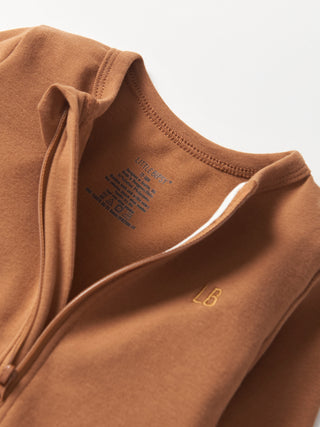 Little Bipsy 2-Way Zip Romper - Chestnut
Close-up of a brown jacket with a brand logo on a light gray background