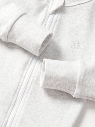 Little Bipsy 2-Way Zip Romper - Light Heather Grey
Close-up of a gray hoodie with a brand logo on a white background