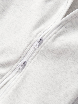 Little Bipsy 2-Way Zip Romper - Light Heather Grey
Close-up of a zipper on a textured white fabric background