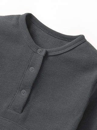 Little Bipsy Waffle Romper - Shadow
Close-up of a dark gray long-sleeve shirt with button details on a white background