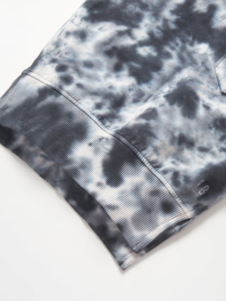 Little Bipsy Marble Pullover - Blue
Close-up of a tie-dye pattern on a fabric with a brand logo.