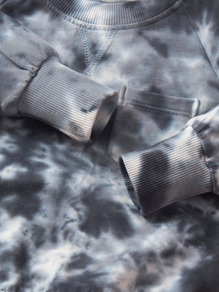 Little Bipsy Marble Pullover - Blue
Close-up of a gray tie-dye sweatshirt with a pocket and rolled-up sleeve.