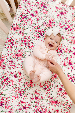 Lou Lou and Company Top and Bottoms - Sophie
Baby in a pink outfit lying on a floral blanket