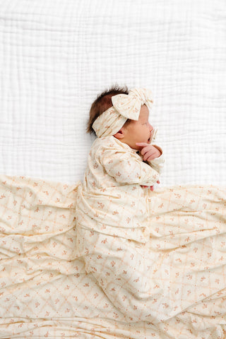 Lou Lou and Company Swaddle Blanket - Annie
Newborn baby wrapped in a white blanket with a bow headband on a white background