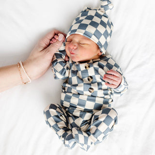Lou Lou and Company Top and Bottoms - Miles
Newborn baby in a blue and white checkered outfit and hat on a white background
