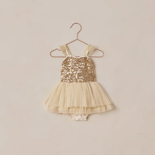 Noralee Clementine Tutu - Champagne
Gold sequin and beige tulle baby dress on a hanger against a beige background